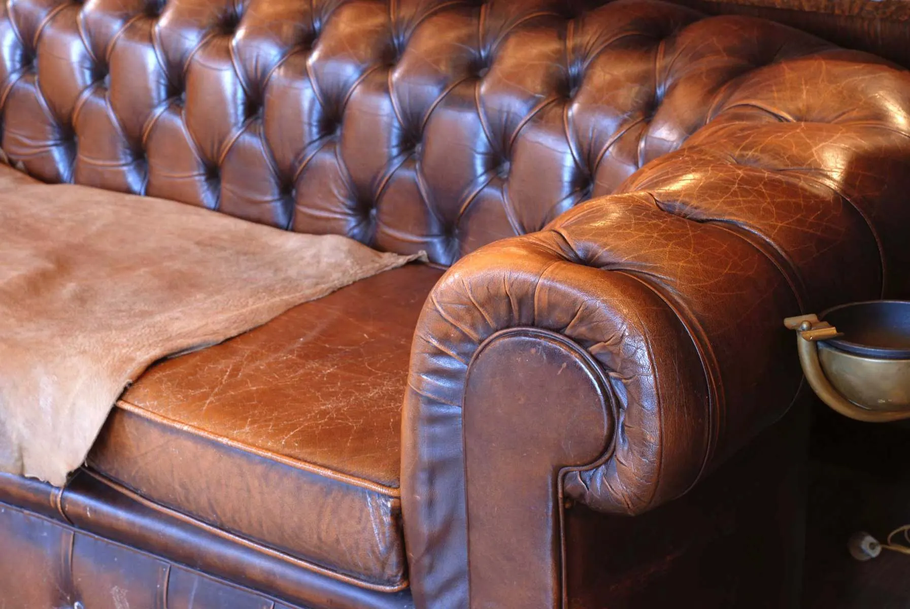 Master craftsman repairing a brown leather sofa, Leathermend Halifax